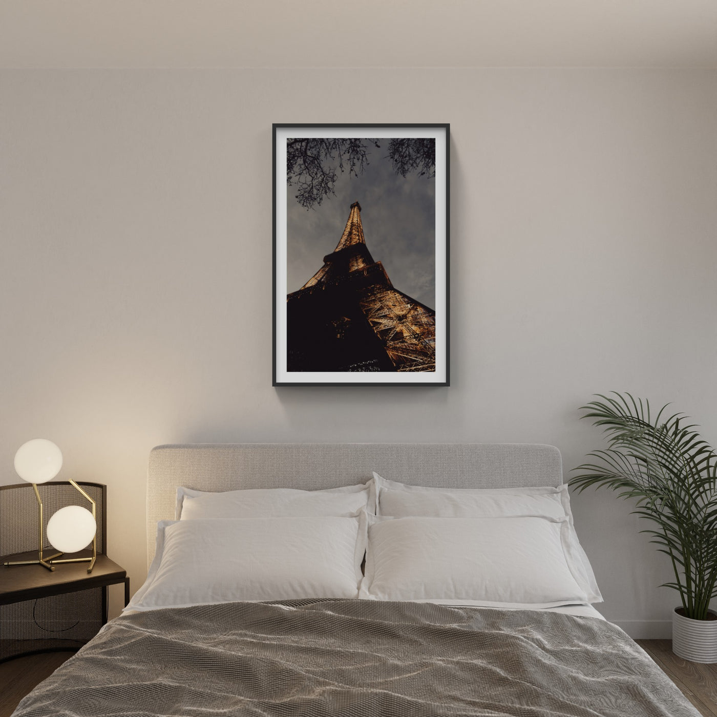 Eiffel Tower lit up at night photo hanging above bed